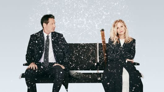 two actors sit on bench in snow