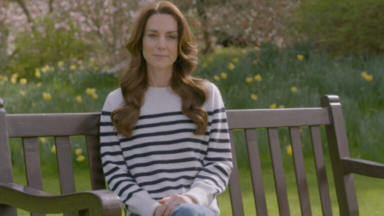 kate middleton sitting on a bench outside