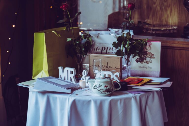 gifts and cards on a table with a "mr and mrs" sign at a wedding