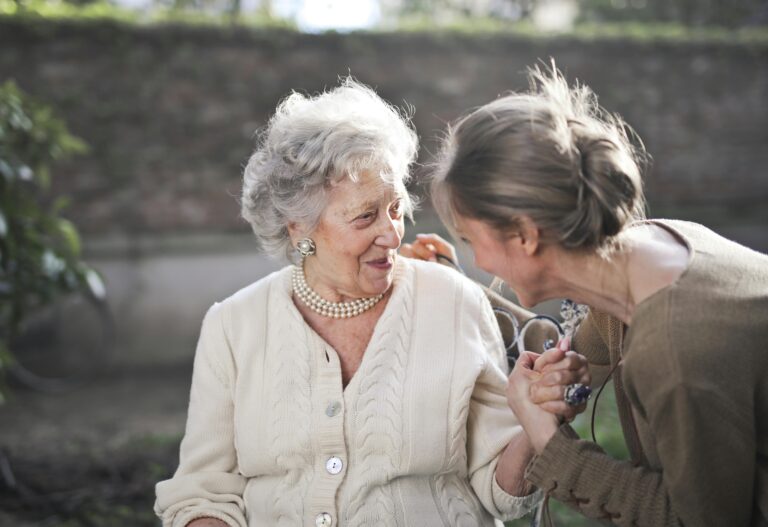 seated older woman smiling at younger woman