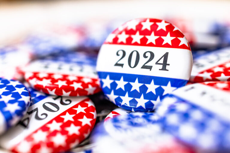 Pile of buttons that say 2024 and have white stars on a blue and red background.