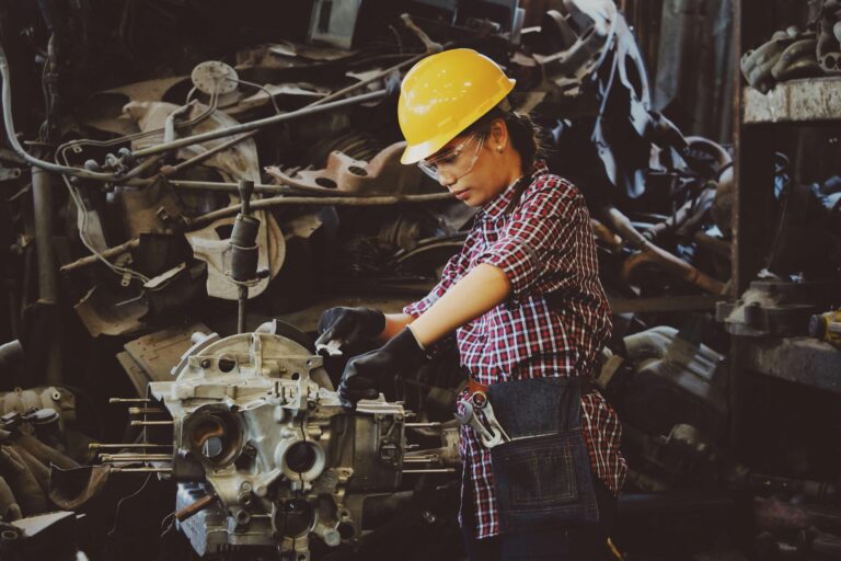 woman in a hardhat working on a car