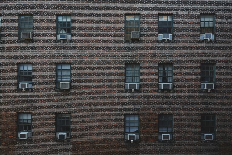 brick apartment building with window AC units