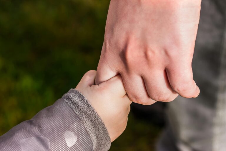 baby holding an adult's hand