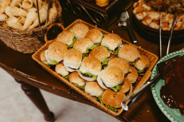 a table of mini sliders and other snacks
