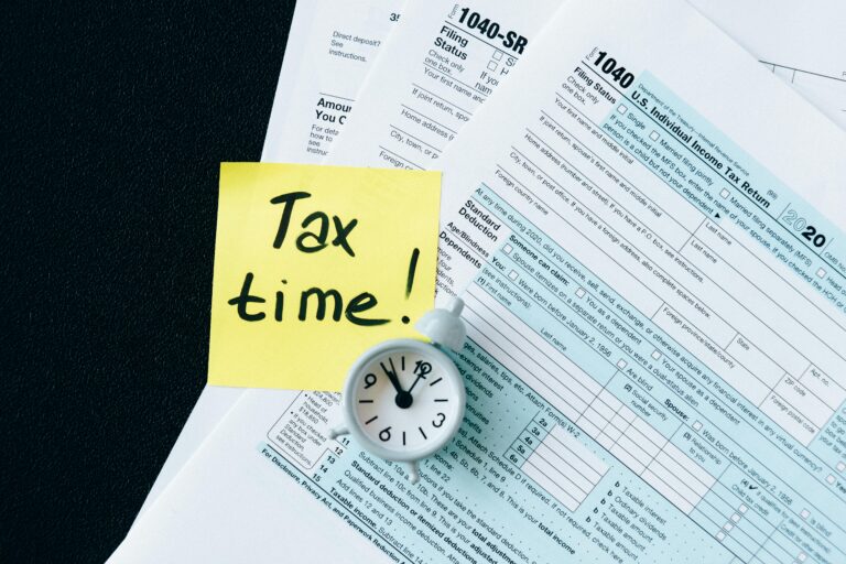 tax documents, a clock, and a post-it note that says "Tax time!"